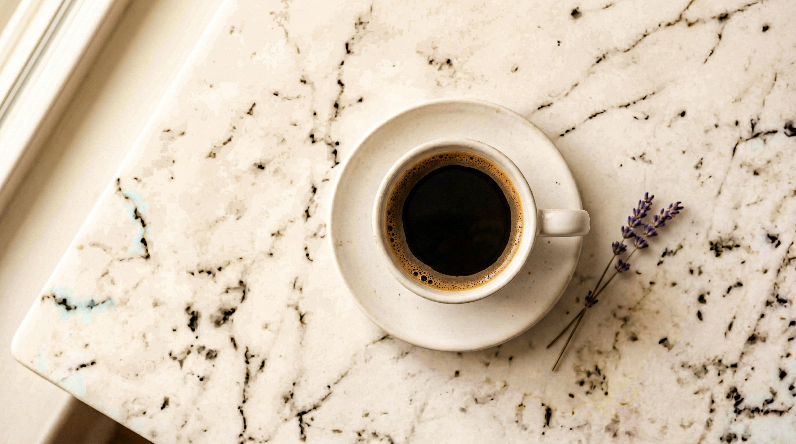 Black coffee in a white ceramic cup on marble surface